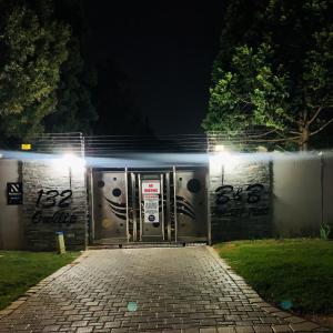 un conjunto de puertas con graffiti en una pared por la noche en Ouklip Place Hotels en Roodepoort