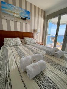 Un dormitorio con una cama grande con toallas. en Beach Apartment La Manga, en La Manga del Mar Menor