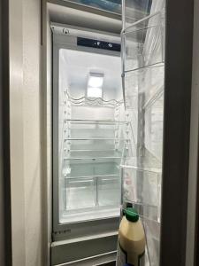 um frigorífico aberto com uma garrafa de bebida em Centric Cozy entire studio in Kallio, Helsinki em Helsinque
