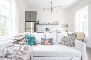 ein Wohnzimmer mit einer weißen Couch mit Kissen in der Unterkunft Neat Suites, The Baldwin Flatts in Covington