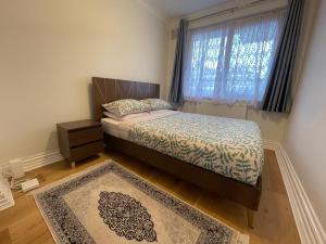 um pequeno quarto com uma cama e uma janela em Homely and very comfortable apartment em Londres