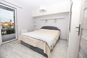 a bedroom with a bed and a large window at Apartament przy Starówce in Elblag