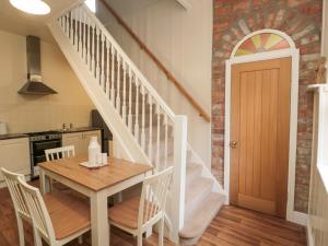 a kitchen and dining room with a table and stairs at Courtyard Cottage in Alnwick