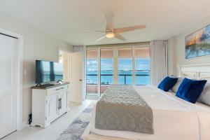 um quarto com uma cama grande e uma ventoinha de tecto em Steps to Beach & Pool - Resort Amenities Galore! em Clearwater Beach