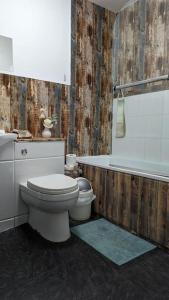 a bathroom with a toilet and a bath tub at The View in Teignmouth