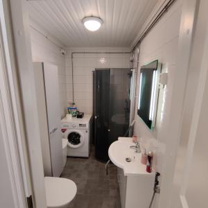 a bathroom with a sink and a washing machine at SEA - 3 Bedrooms in Kristiinankaupunki