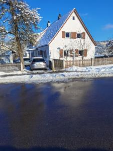 samochód zaparkowany przed domem w śniegu w obiekcie s´Paradies Ferienwohnung w mieście Beilngries