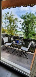 Habitación con vistas a un balcón con mesa y sillas. en Grand F3 - Emplacement d'or proche Paris et Versailles, en Plaisir