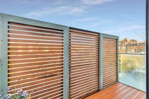 a large metal garage door on a wooden deck at Chic Kensal Green Retreat in London