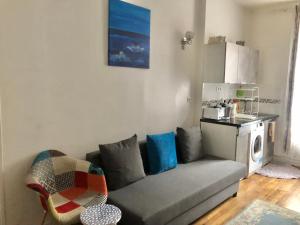 a living room with a couch and a kitchen at Nice Apartment ideal to visit Paris in Clichy