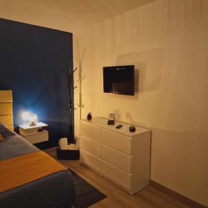 um quarto com uma cama e uma televisão na parede em les chambres de Sandra em Volognat