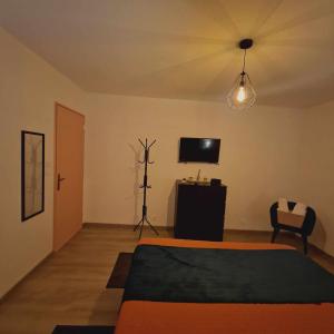 um quarto com uma cama e uma televisão de ecrã plano em les chambres de Sandra em Volognat