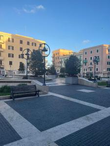 a park with a bench and some buildings at La Piazzetta Anzio in Anzio