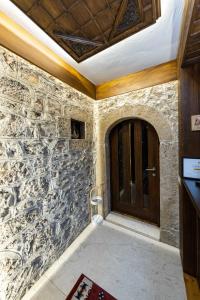 a stone wall with a door in a room at Hotel - Kulla e Zenel Beut in Peje