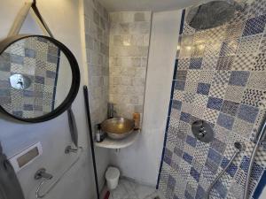 La salle de bains est pourvue d'une douche avec un miroir et un lavabo. dans l'établissement Beautiful studio in the center of sidi bou said village, à Sidi Bou Saïd