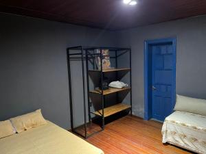 ein Zimmer mit einem Bett und einem Bücherregal neben einer blauen Tür in der Unterkunft Quinta Mitre in San Nicolás de los Arroyos