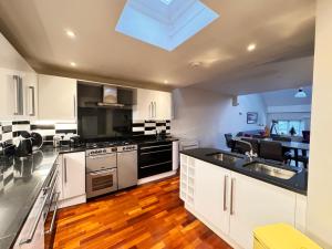 cocina con electrodomésticos de acero inoxidable y ventana grande en Spacious and Refreshing 3-4 Bed Stamford House! en Stamford
