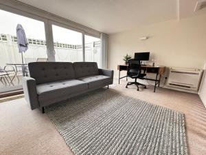 a living room with a couch and a desk at Spacious and Refreshing 3-4 Bed Stamford House! in Stamford