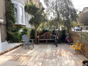 a patio with a bench and a bike parked next to a house at London Central Richmond Cozy Apartment in Richmond