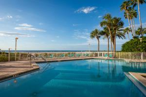 uma piscina com palmeiras e uma praia em Steps to Beach & Pool - Resort Amenities Galore! em Clearwater Beach