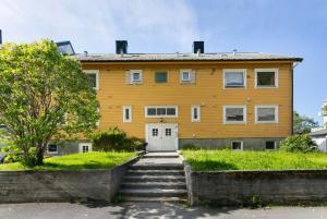 ein gelbes Haus mit Treppe davor in der Unterkunft Centrum apartment in Ålesund