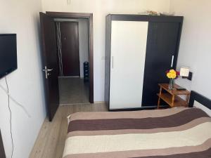 Schlafzimmer mit einem Bett und einer Tür mit einem TV in der Unterkunft Апартамент Панорама in Chissarja