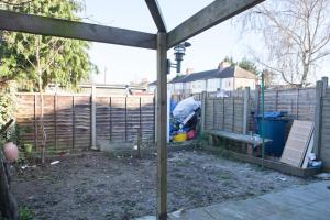 a backyard with a wooden fence and a wooden pergola at Sleek 3Bed/3Bathroom Flat@Harrow in Hatch End