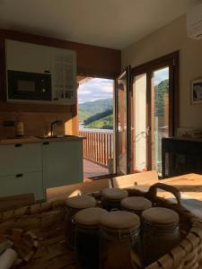 a kitchen with a table with stools and a balcony at Casa Aturuxo in Belesar