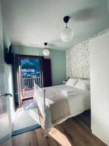 1 dormitorio con 1 cama grande y balcón en Casa Aturuxo, en Belesar