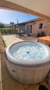 una gran bañera de hidromasaje en un tubo de mimbre en Villa de charme Mas de la Cigaline & chambres d'hôtes chez Dany 83, en Garéoult