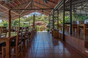 un restaurante vacío con mesas y sillas de madera en Bongo - Adults Only en Manuel Antonio