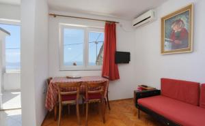 a living room with a table and a red couch at Apartments Aurora Adriatica in Brist