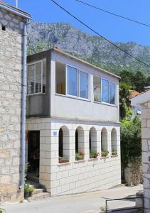 a house with windows and a mountain in the background at Apartments Aurora Adriatica in Brist