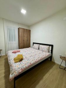 1 dormitorio con 1 cama con manta y almohadas en The ONE Suites- with terrace in City Center en Kumanovo