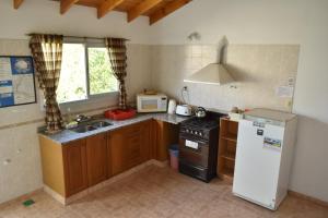 a kitchen with a white refrigerator and a sink at Complejo Turístico Hostal Madryn in Puerto Madryn +20 photos