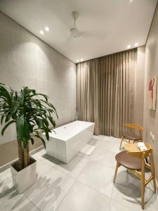 a bathroom with a tub and a plant and a chair at FR Hotel in Ibagué