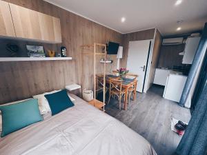 ein Schlafzimmer mit einem Bett und einem Tisch sowie eine Küche in der Unterkunft La parenthèse de Sully in Saint-Péray