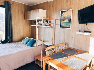 een slaapkamer met een bed en een tafel en een televisie bij La parenthèse de Sully in Saint-Péray