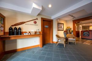 a lobby with a bar with bottles and chairs at Sidney Waterfront Inn & Suites in Sidney