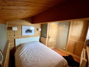 a bedroom with a bed in a room with wooden ceilings at Chalet familial idéal 2 familles nombreuses Ski aux pied 12 pers Plagne Soleil in La Plagne Tarentaise