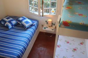 - une petite chambre avec un lit et une fenêtre dans l'établissement Casa na quadra da Praia do Tenório, à Ubatuba