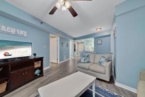 ein Wohnzimmer mit einem TV und einem Sofa in der Unterkunft Harbour Place 210 in Gulf Shores
