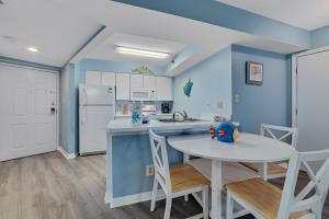 eine Küche mit blauen Wänden sowie einem Tisch und Stühlen in der Unterkunft Harbour Place 210 in Gulf Shores