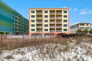 ein Gebäude am Strand neben einigen Gebäuden in der Unterkunft Harbour Place 210 in Gulf Shores