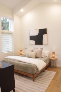 1 dormitorio con 1 cama grande y paredes blancas en Centrally located modern townhome free parking, en Chattanooga