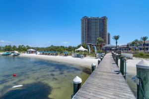 a wooden pier leading to a beach with a building at Portofino Island P4-605 in Pensacola Beach