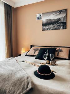 ein Bett mit schwarzem Hut und Brille darauf in der Unterkunft HELLO GIEWONT in Zakopane
