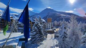 a ski resort with snow covered trees and a mountain at B&B VALCHISONE in Pinasca 