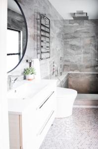 een witte badkamer met een wastafel en een spiegel bij Sweet Lancaster Apt. B in Lancaster