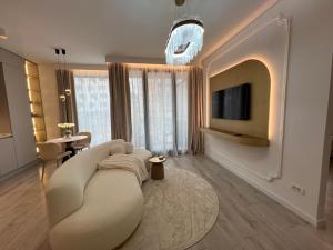 uma sala de estar com um sofá e uma televisão em Harmony property WIN HERASTRAU em Bucareste